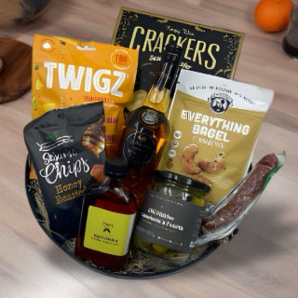 a metal tray filled with crackers, pretzels, mixed nuts, chips, cured sausage, pickles, local spicy maple syrup and award winning whisky from Dunrobin Distilleries.  Gift Baskets for him in Ottawa.