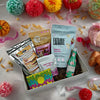 birthday themed popcorn, scone mix, birthday nut mix, birthday chocolate bar 'birthday babe' bath soak and small bottle of bubbly