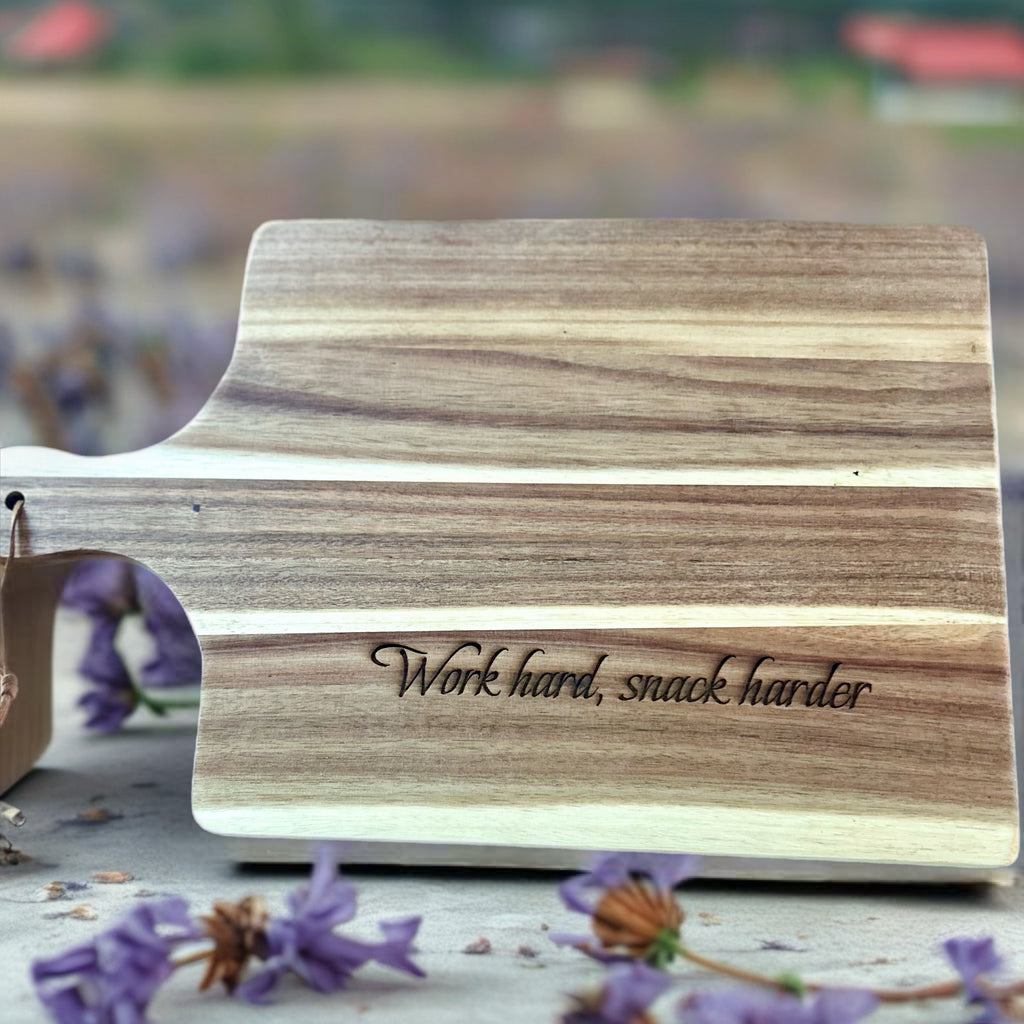 Wooden Acacia cutting board with 'Work hard, snack harder' engraving.  Cusomize with your own message or logo for a great corporate gift in Ottawa