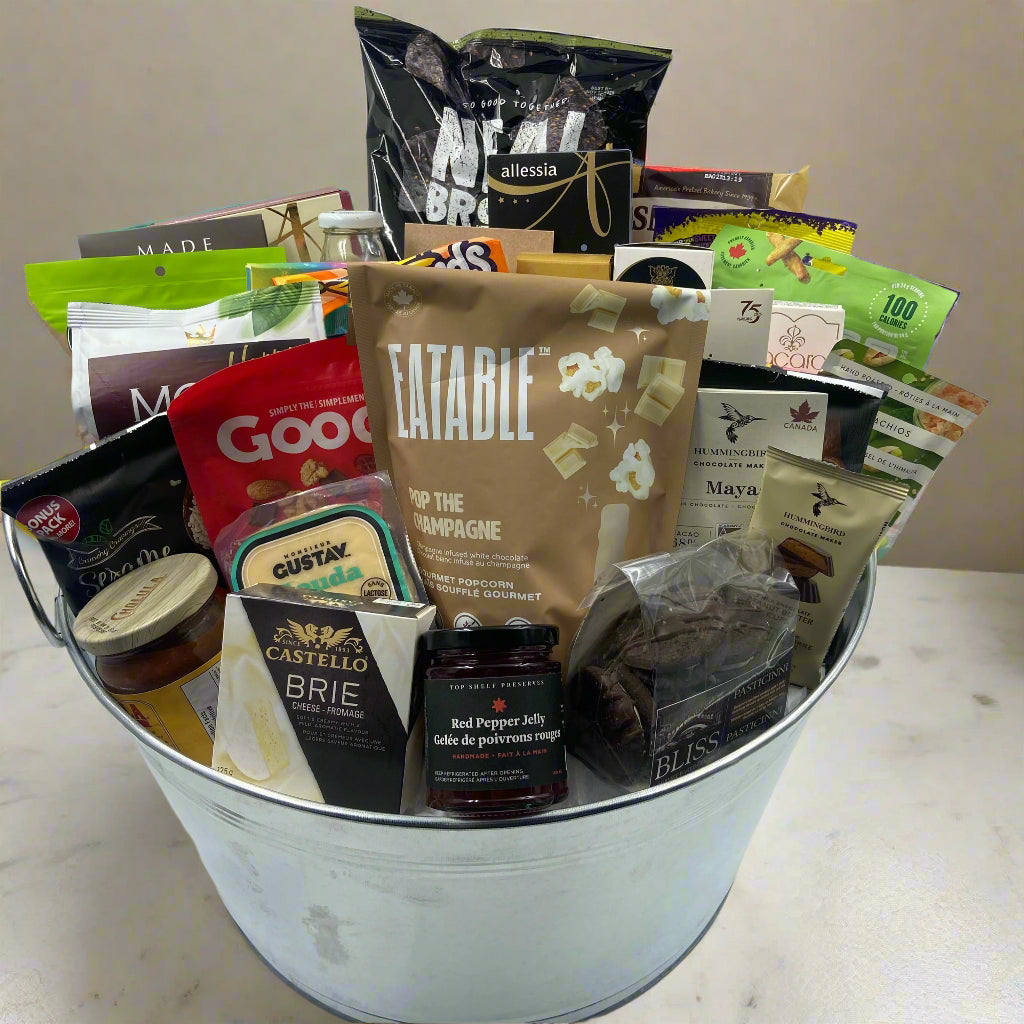 “Impress a team or office with The Grand Indulgence Basket — a large metal bucket filled with chocolates, cookies, shortbread, nuts, crackers, pretzels, chips, cheeses, salsa, and gourmet spreads. A shareable gift for any celebration. Great realtor gifts in Ottawa
