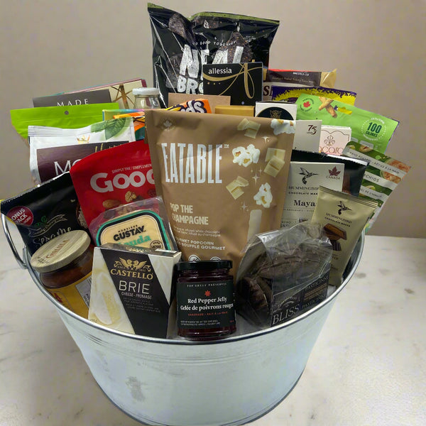 “Impress a team or office with The Grand Indulgence Basket — a large metal bucket filled with chocolates, cookies, shortbread, nuts, crackers, pretzels, chips, cheeses, salsa, and gourmet spreads. A shareable gift for any celebration. Great realtor gifts in Ottawa