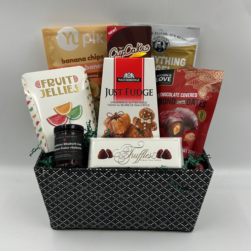 Gift basket filled with gluten free goodies including fudge, banana chips, cupcakes, nuts, chocolate covered dates, candy, truffles and jam