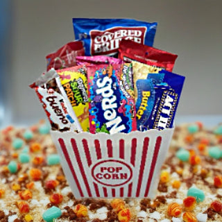 Popcorn container filled with candies and chocolate and popcorn