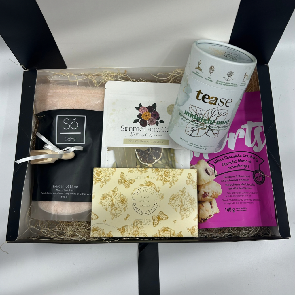 The Tranquil Moments Box brings a touch of calm and comfort to any day. Inside, discover soothing bath salts with a wooden scoop for the perfect dose of relaxation, stovetop potpourri to fill the air with warm, natural aromas, a premium local chocolate bar, gourmet tea to sip and unwind, and decadent shortbread for a sweet indulgence. This box is a thoughtful gift for anyone in need of a peaceful retreat at home.